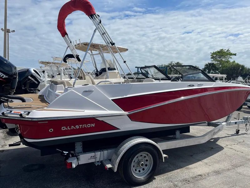 Slide: The Image of 2018 Glastron GTD boat with red and white exterior on a trailer. - 2