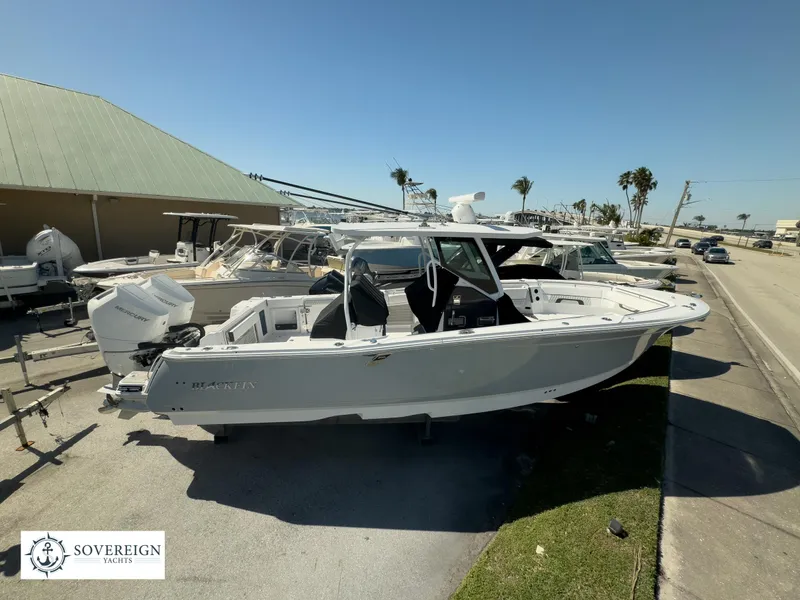 Slide: The Image of 2024 Blackfin 302CC boat displayed outdoors at Sovereign Yachts dealership. - 1