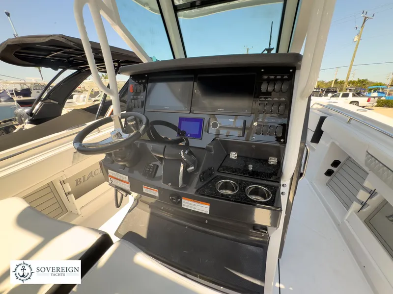 Slide: The Image of 2024 Blackfin 302CC boat cockpit with advanced navigation controls and dual steering wheels. - 28