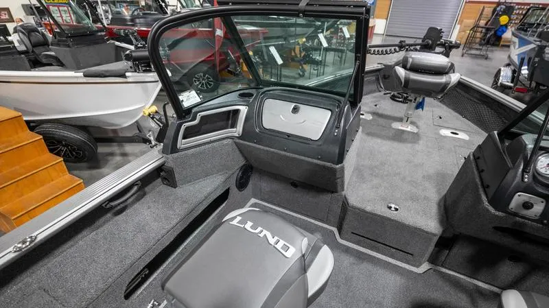 Slide: The Image of 2024 Lund 2025 Impact XS Sport boat interior with seating and storage compartments. - 11