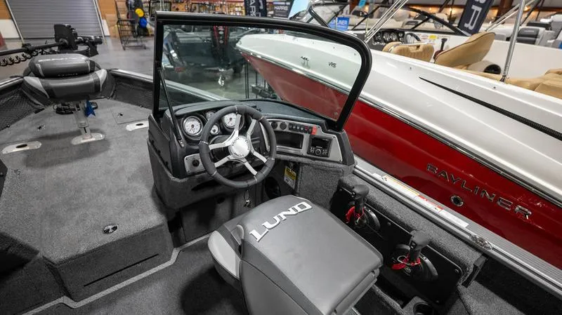 Slide: The Image of 2024 Lund 2025 Impact XS Sport boat interior with steering wheel and dashboard. - 12