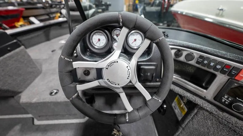 Slide: The Image of 2024 Lund 2025 Impact XS Sport boat steering wheel and dashboard. - 15