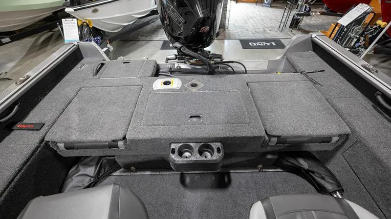 Slide: The Image of 2024 Lund 2025 Impact XS Sport boat interior with motor and storage compartments. - 17