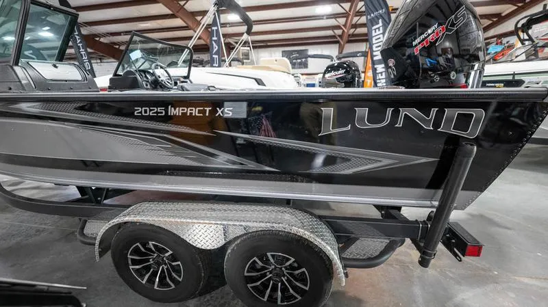 Slide: The Image of 2024 Lund 2025 Impact XS Sport boat on a trailer in a showroom. - 3