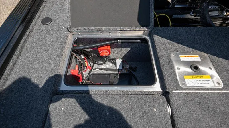 Slide: The Image of 2024 Lund 1875 Pro-V Bass XS battery compartment with wiring and safety label. - 10