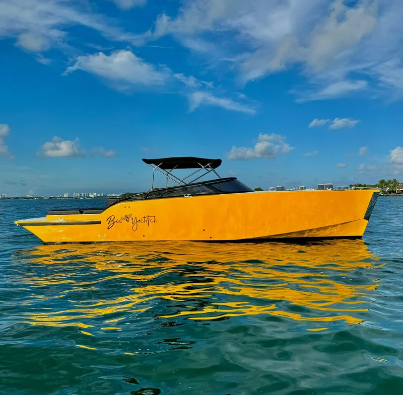 Slide: The Image of Bright yellow 2023 VanDutch Sport 35 yacht on calm blue waters under a clear sky. - 2