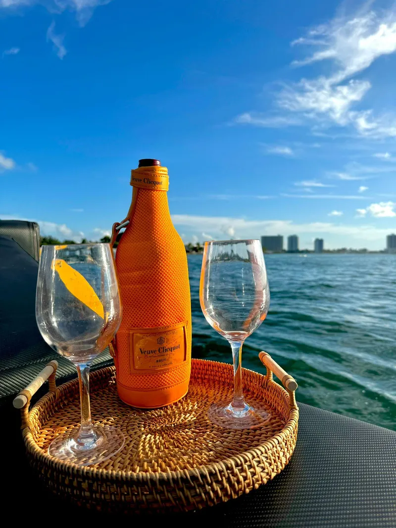Slide: The Image of Champagne and glasses on a VanDutch Sport 35 yacht, 2023, with ocean and city skyline. - 8