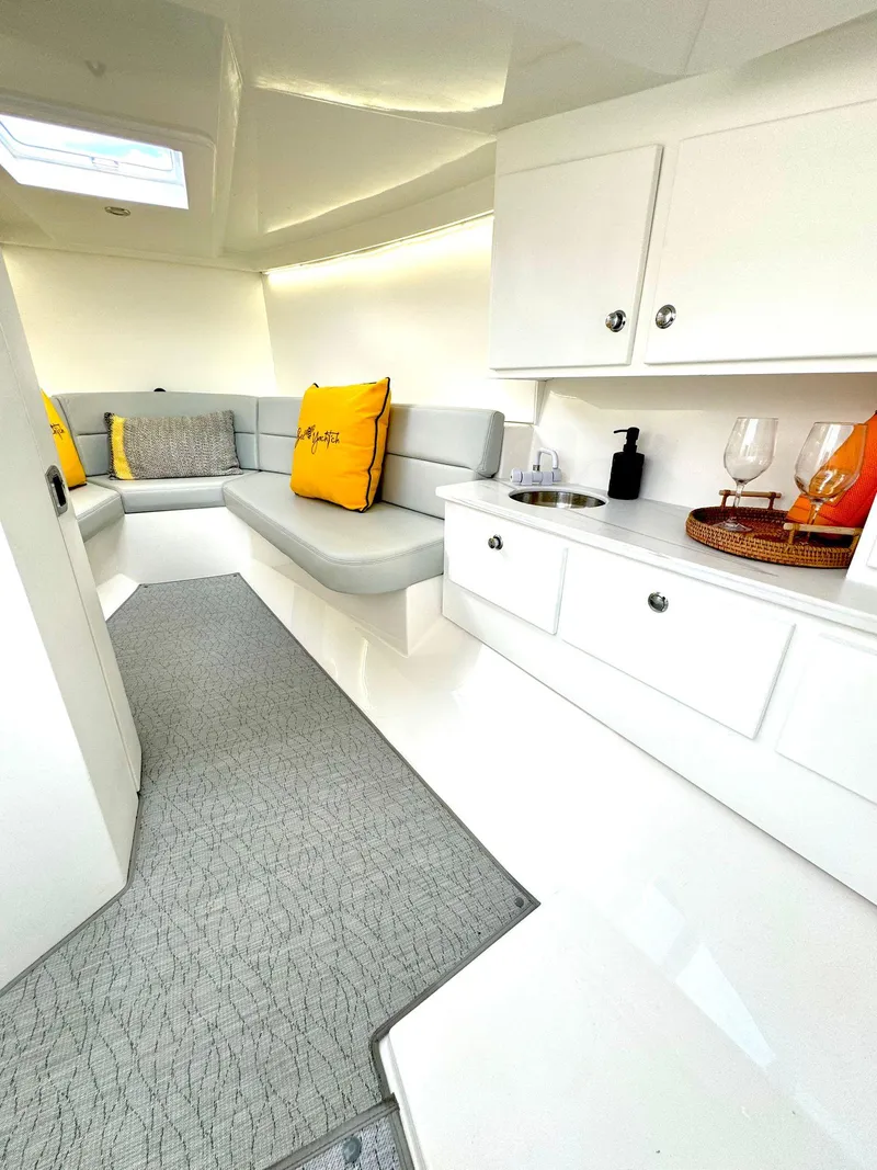 Slide: The Image of Interior of 2023 VanDutch Sport 35 yacht with modern white cabinetry and cozy seating. - 9