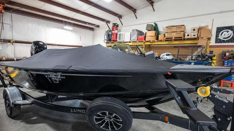 Slide: The Image of 2024 Lund 1875 Pro-V Bass XS boat covered in a garage. - 35