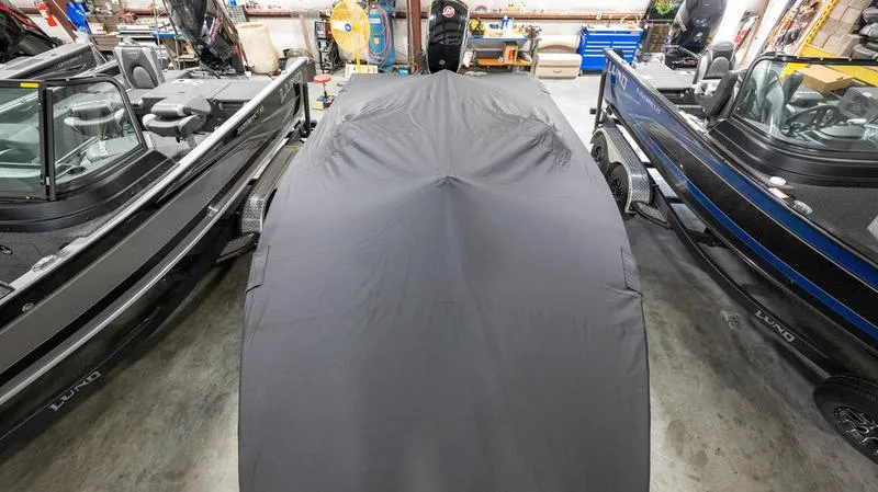 Slide: The Image of 2024 Lund 1875 Pro-V Bass XS boat covered in a garage. - 36