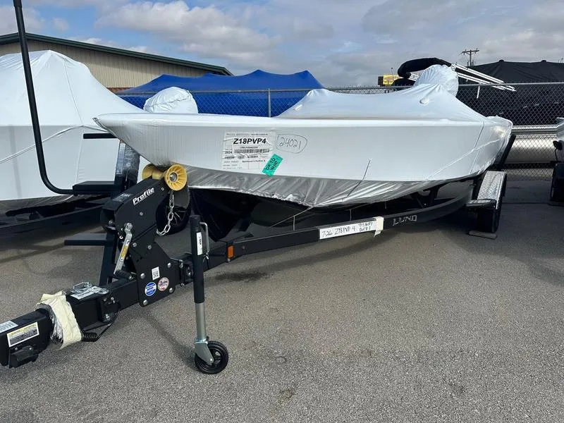 Slide: The Image of 2024 Lund 1875 Pro-V Bass XS boat wrapped in protective cover on a trailer. - 37