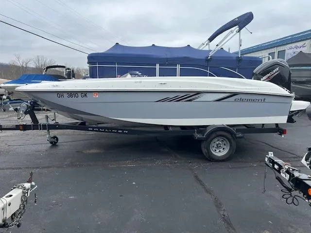 Slide: The Image of 2023 Bayliner Element E18 boat on trailer in parking lot. - 2