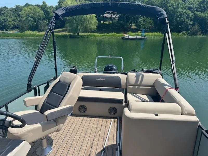 Slide: The Image of 2024 Harris Cruiser 230 SL on a serene lake. - 2