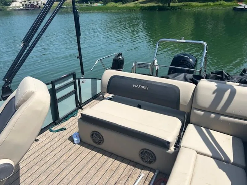 Slide: The Image of 2024 Harris Cruiser 230 SL pontoon boat on a serene lake. - 7