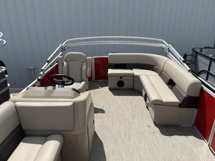 Slide: The Image of 2024 Bentley Pontoons LE 180 3 PT interior with beige seating and red accents. - 12