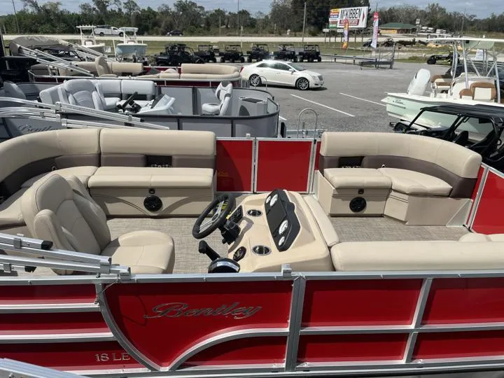 Slide: The Image of 2024 Bentley Pontoons LE 180 3 PT, red and beige interior, on display at dealership. - 7
