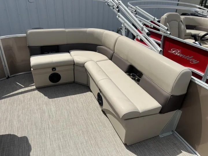 Slide: The Image of 2024 Bentley Pontoons LE 180 CR interior seating area with beige and brown upholstery. - 12