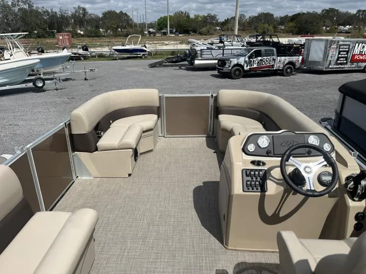 Slide: The Image of 2024 Bentley Pontoons LE 180 CR interior with beige seating and steering console. - 15