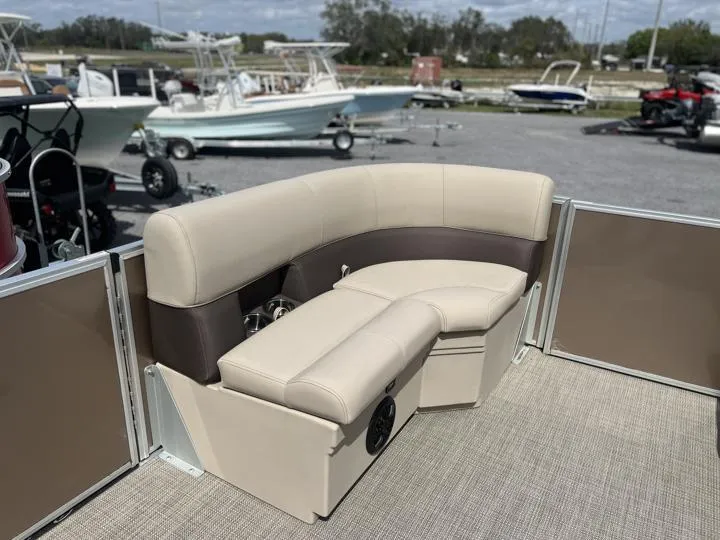 Slide: The Image of 2024 Bentley Pontoons LE 180 CR interior seating area with beige and brown upholstery. - 17