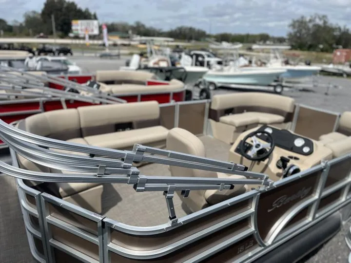 Slide: The Image of 2024 Bentley Pontoons LE 180 CR pontoon boat with beige seating and steering console. - 6