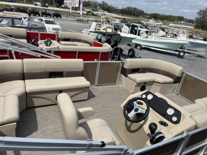 Slide: The Image of 2024 Bentley Pontoons LE 180 CR interior with beige seating and modern dashboard. - 7