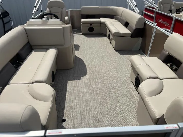Slide: The Image of 2024 Bentley Pontoons LE 180 CR interior with beige seating and spacious layout. - 9