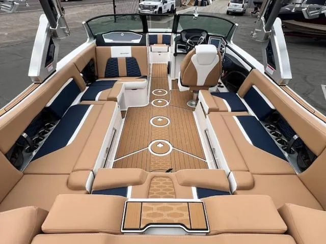 Slide: The Image of 2024 MasterCraft X24 boat interior with beige and blue seating. - 12