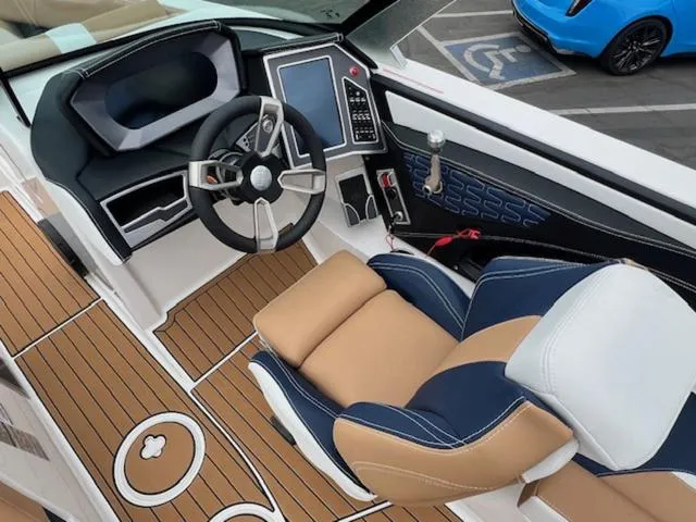 Slide: The Image of 2024 MasterCraft X24 boat interior with beige and blue seating. - 13