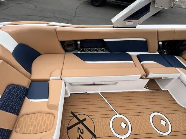 Slide: The Image of 2024 MasterCraft X24 boat interior with beige and blue seating. - 15