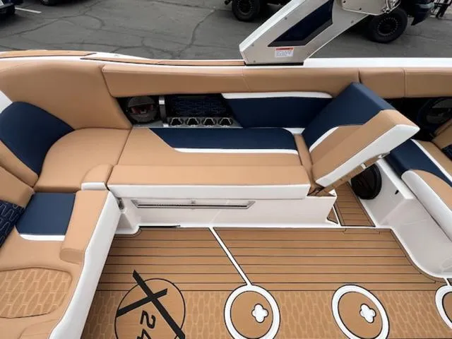 Slide: The Image of 2024 MasterCraft X24 boat interior with beige and blue seating. - 16