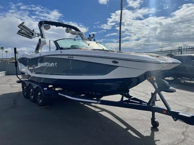 Slide: The Image of 2024 MasterCraft X24 boat on a trailer in a parking lot. - 4