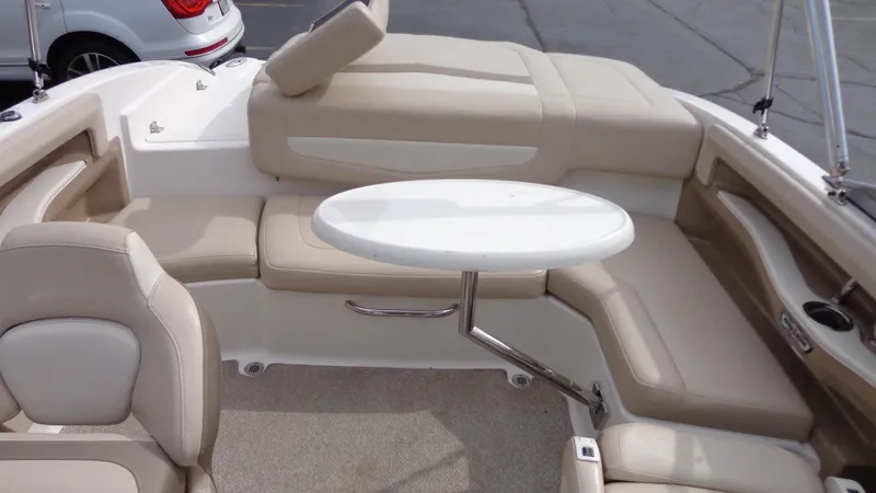 Slide: The Image of 2011 Chaparral 206 SSi boat interior with beige seating and a white table. - 25