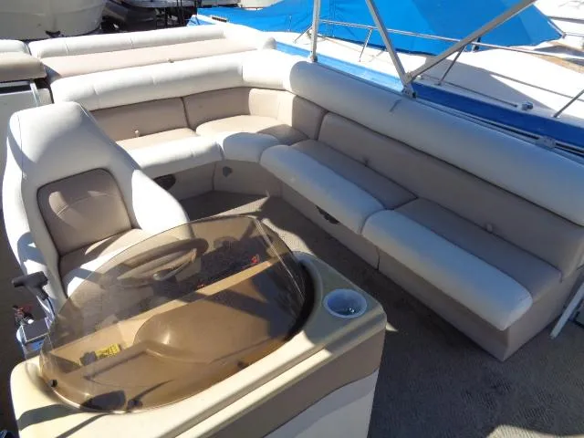 Slide: The Image of 2004 Sylvan Sunchaser 824 pontoon boat interior with beige seating and helm. - 5
