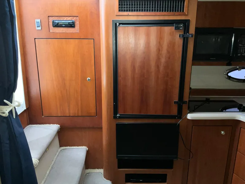 Slide: The Image of Interior of 2002 Cruisers Express boat with wooden cabinetry and built-in appliances. - 13