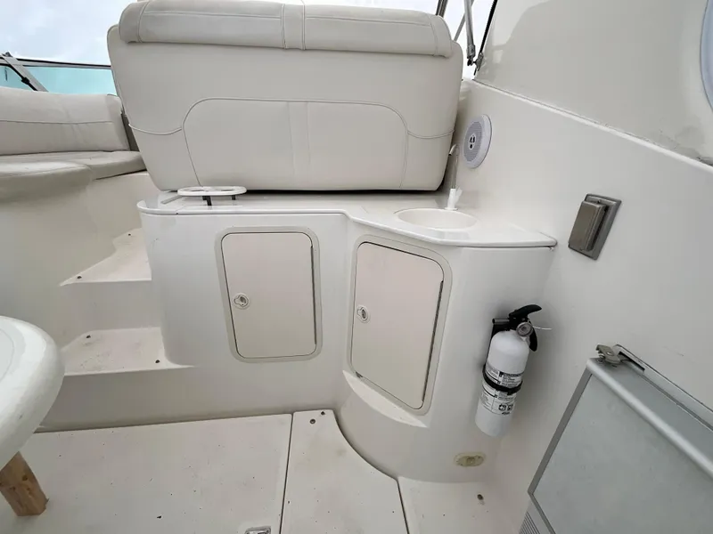 Slide: The Image of 2002 Cruisers Express boat interior with white seating, storage compartments, and a fire extinguisher. - 7