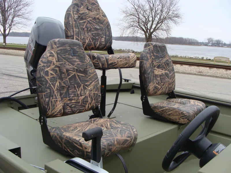 Slide: The Image of 2023 Lowe RX 1660 SC boat with camo seats and steering wheel, parked near a lake. - 8