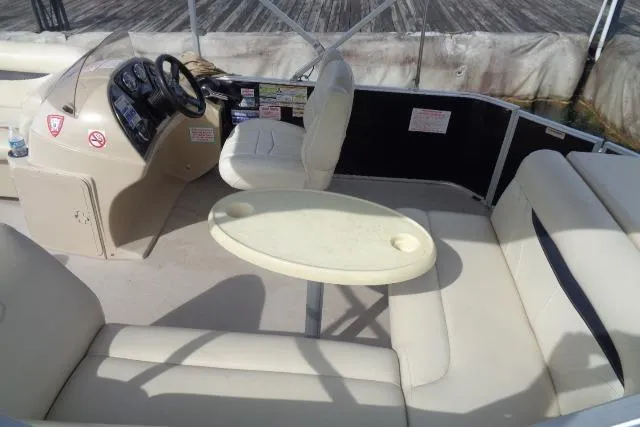 Slide: The Image of 2017 Godfrey Sweetwater boat interior with beige seating and steering console. - 34