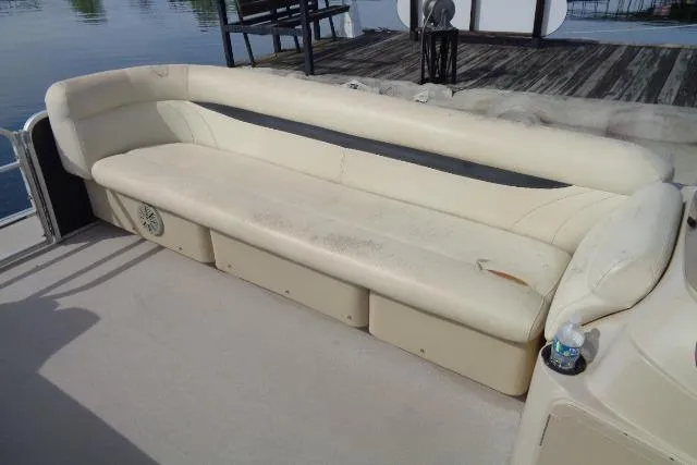 Slide: The Image of 2017 Godfrey Sweetwater boat with beige seating, docked by the water. - 36