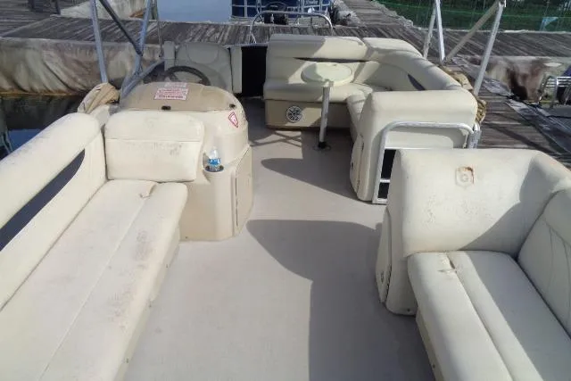 Slide: The Image of 2017 Godfrey Sweetwater boat interior with beige seating and helm, docked at marina. - 41