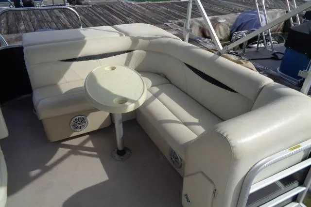 Slide: The Image of 2017 Godfrey Sweetwater boat with beige seating and small round table on deck. - 42