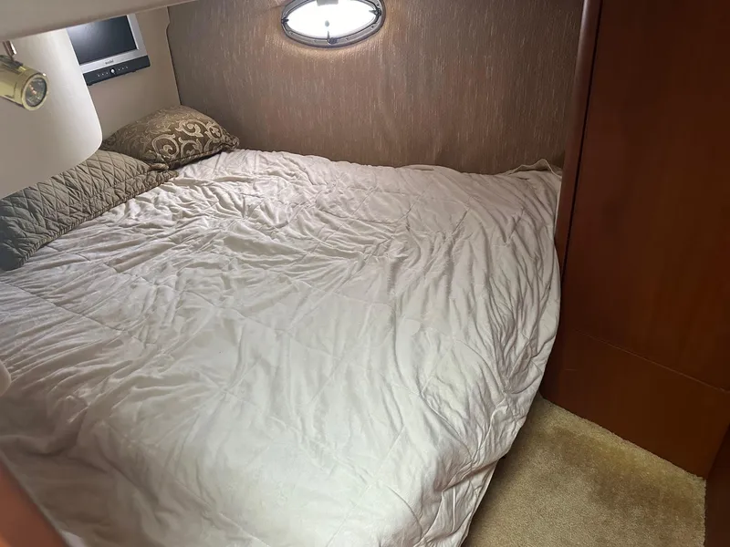 Slide: The Image of 2005 Silverton 38 Sport Bridge cabin with cozy bed and porthole window. - 13