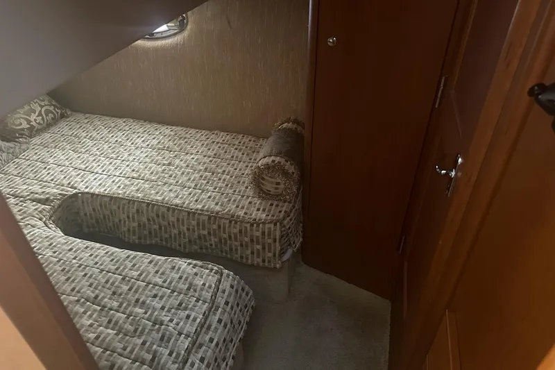 Slide: The Image of Cozy cabin interior of 2005 Silverton 38 Sport Bridge with twin beds and wooden accents. - 17
