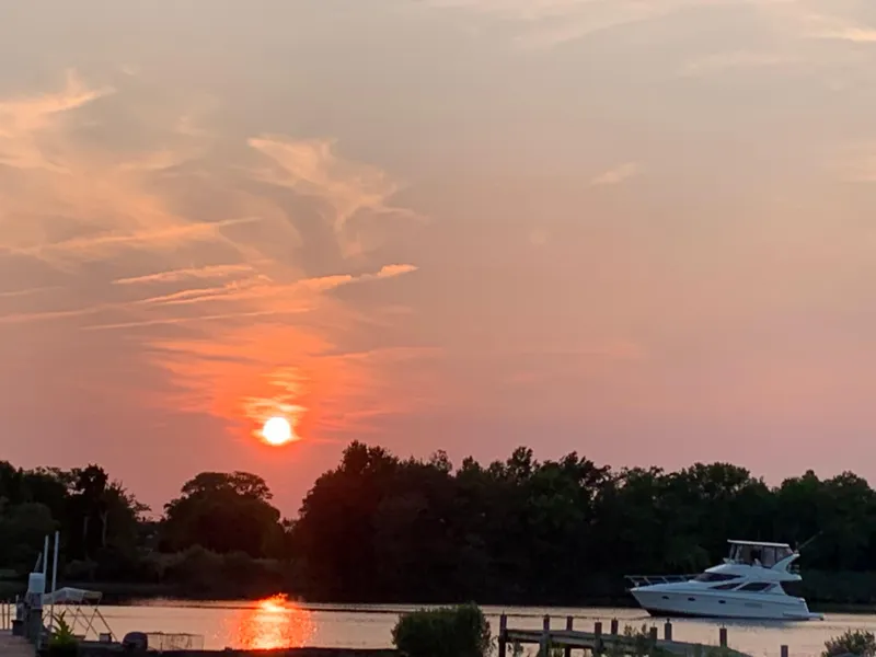 Slide: The Image of Sunset over a river with a 2005 Silverton 38 Sport Bridge yacht. - 20