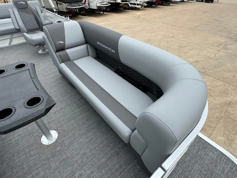 Slide: The Image of 2024 Bennington 22 S Swingback pontoon boat with gray seating and cupholder table. - 12