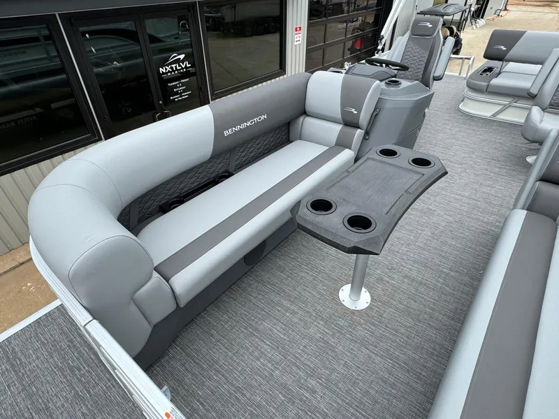 Slide: The Image of 2024 Bennington 22 S Swingback pontoon boat interior with gray seating and cup holders. - 13