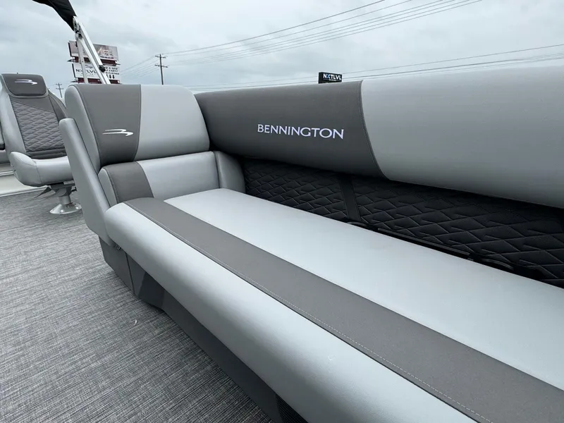 Slide: The Image of 2024 Bennington 22 S Swingback boat interior with gray seating and logo. - 14
