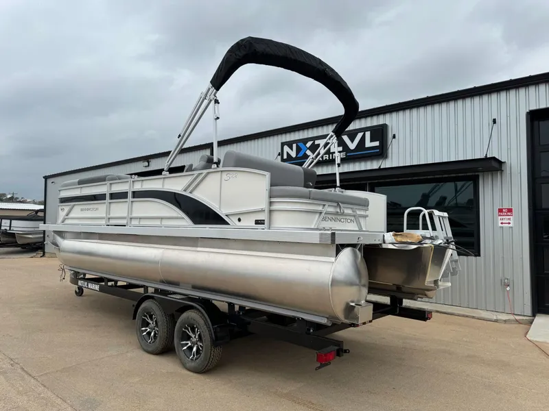 Slide: The Image of 2024 Bennington 22 S Swingback pontoon boat on trailer outside dealership. - 4