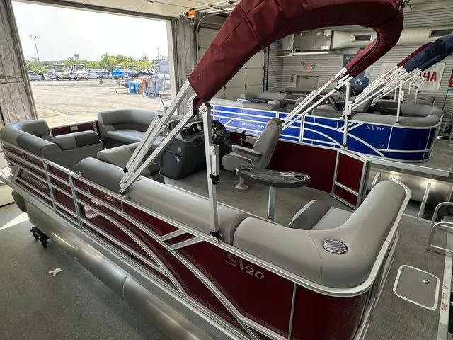 Slide: The Image of 2024 Bennington 20 SVL pontoon boat with maroon and gray seating in showroom. - 11