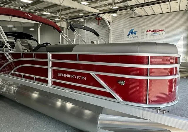 Slide: The Image of 2024 Bennington 20 SVL pontoon boat in showroom, featuring sleek red design. - 15