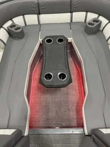 Slide: The Image of 2024 Bennington 25 LTSB boat interior with gray seating and cup holders. - 13